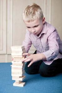 Boy concentrating while stacking blocks