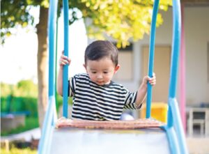 Boy Climbing Up a Slide