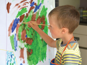 Boy painting at easel