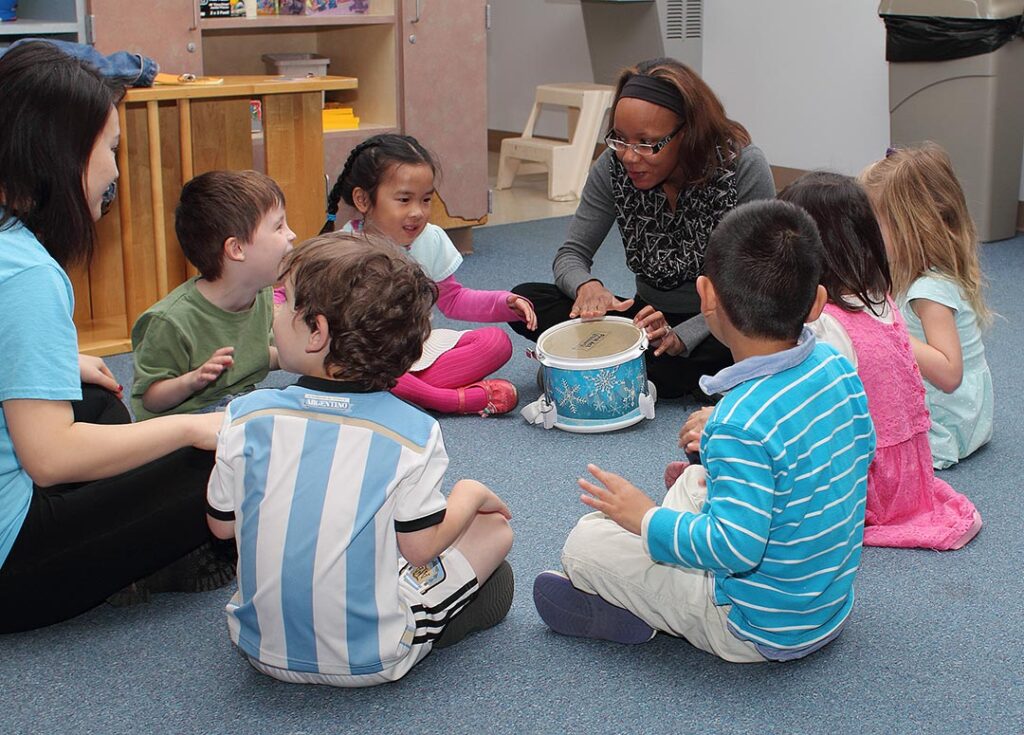 Teacher with drum and students