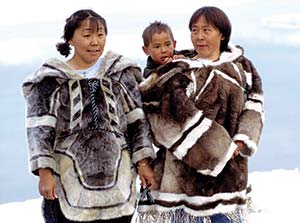 An eskimo family wearing furry coats