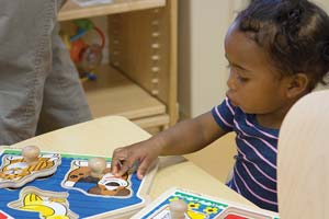 Toddler with a knob puzzle