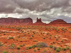 A picture of an open desert plain with tall plateaus in the distance