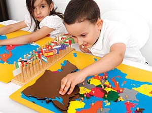 Little boy is playing with toy in the classroom