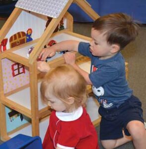 two children with a dollhouse