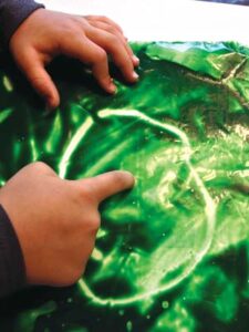 child drawing with paint inside a ziplock bag