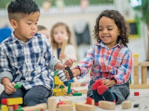 A boy and a girl play with blocks together