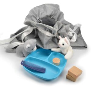 a story bag with toy kittens, a ball, a dish, and a comb