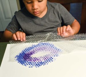 Child painting with bubble wrap