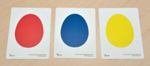 Egg cards in red, blue, and yellow lined up